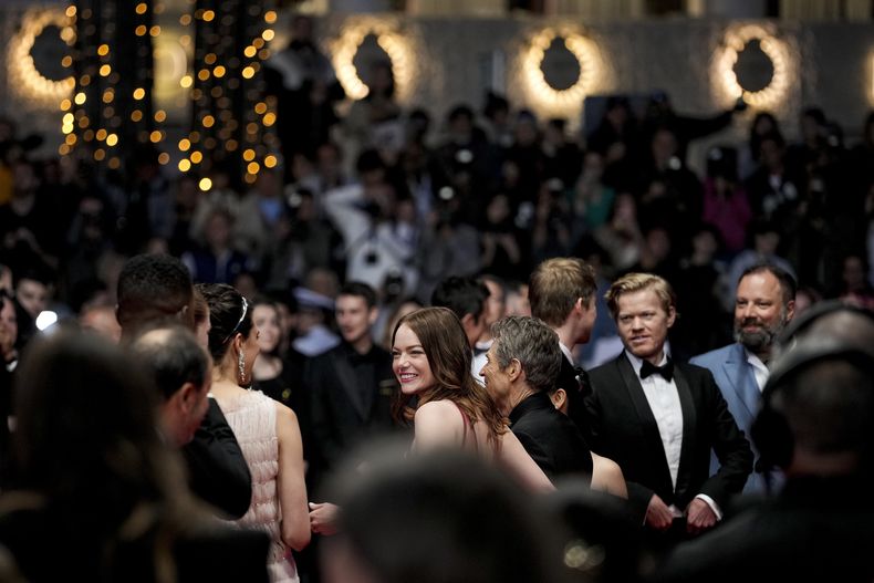Emma Stone, centro, posa para retratos al salir de la premiere de Kinds of Kindness en la en 77a edición del Festival de Cine de Cannes en Francia, el viernes 17 de mayo de 2024. (Foto Andreea Alexandru/Invision/AP)