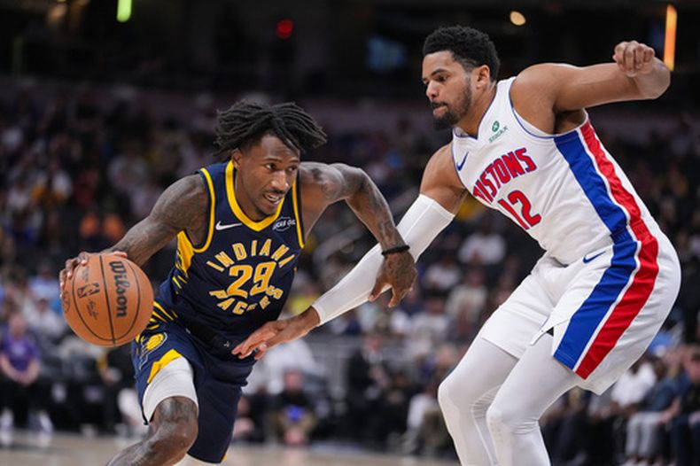 Quenton Jackson (29), base de los Pacers de Indiana, conduce el balón ante Tobias Harris (12), alero de los Pistons de Detroit, durante la primera mitad de un juego de baloncesto de la NBA en Indianápolis, el domingo 12 de abril de 2026. (Foto AP/Michael Conroy)