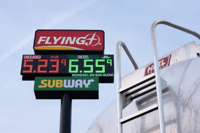 Precios de la gasolina cerca de un vehículo que transporta combustible en una gasolinería, el martes 7 de abril de are 2026, en Aurora, Oregon. (AP Photo/Jenny Kane)