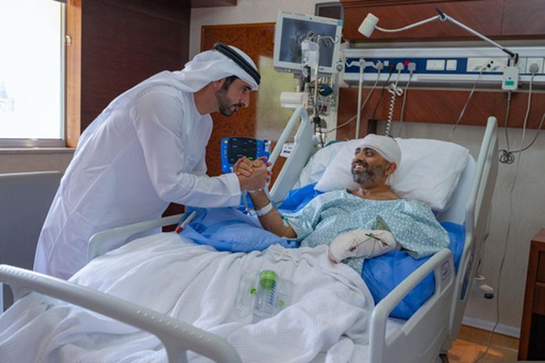En esta imagen publicada por la Oficina de Medios del gobierno de Dubái, el príncipe heredero de Dubái, el jeque Hamdan bin Mohammed bin Rashid Al Maktoum, a la izquierda, visita al piloto indio herido de Flydubai Smit Machchhar en un hospital de Abu Dabi, Emiratos Árabes Unidos, el viernes 2 de octubre de 2026. (Oficina de Medios del gobierno de Dubái via AP)