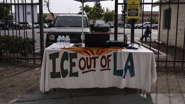 Una mesa cubierta con un mantel en el que se lee ICE fuera de Los Ángeles se encuentra bajo un toldo junto al centro de empleo para jornaleros, afuera de una tienda Home Depot en el barrio de Van Nuys, en Los Ángeles, el 28 de agosto de 2025. (AP Foto/Jae C. Hong)
