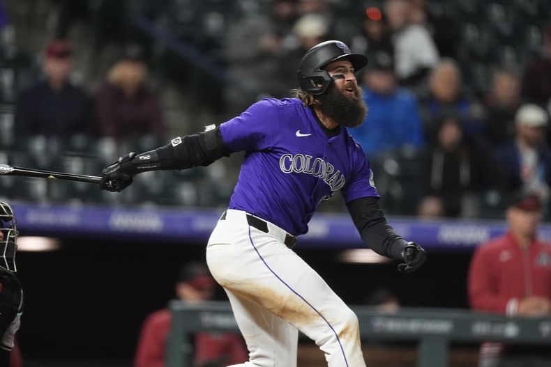 Charlie Blackmon, de los Rockies de Colorado, sigue el vuelo de su jonrón solitario contra el relevista Luis Frías, de los Diamondbacks de Arizona, en la octava entrada del juego de béisbol del lunes 8 de abril de 2024, en Denver. (AP Foto/David Zalubowski)