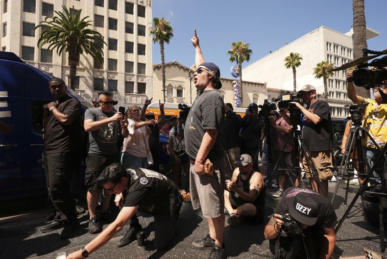 Visitantes rinden homenaje en la estrella de Ozzy Osbourne en el Paseo de la Fama de Hollywood el martes 22 de julio de 2025, en Los Ángeles. (Foto AP/Damian Dovarganes)