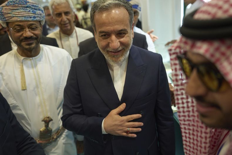 El ministro de Exteriores de Irán, Abbas Araghchi (centro) y su homólogo de Omán, Badr al-Busaidi (izquierda), visitan la Feria Internacional del Libro en Mascate, Omán, el 25 de abril de 2025. (AP Foto/Fatima Shbair)
