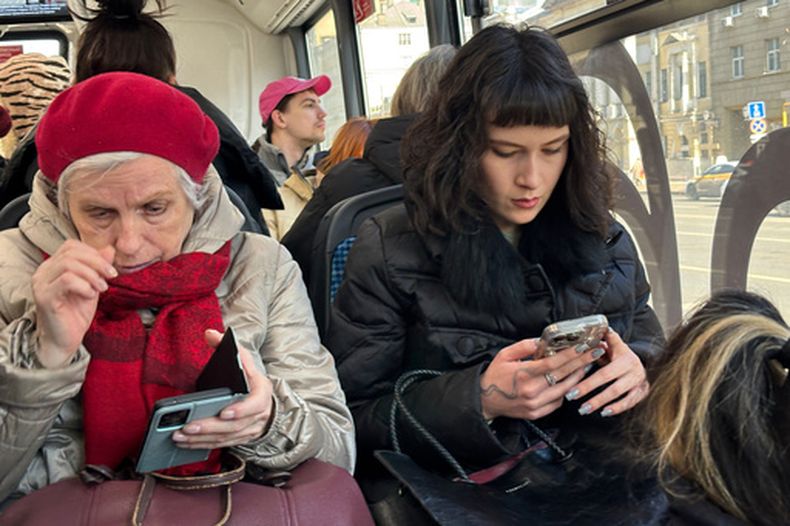 ARCHIVO - Dos mujeres consultan sus celulares durante un viaje en bus en Moscú, el 11 de marzo de 2026. (AP Foto/Alexander Zemlianichenko, archivo)