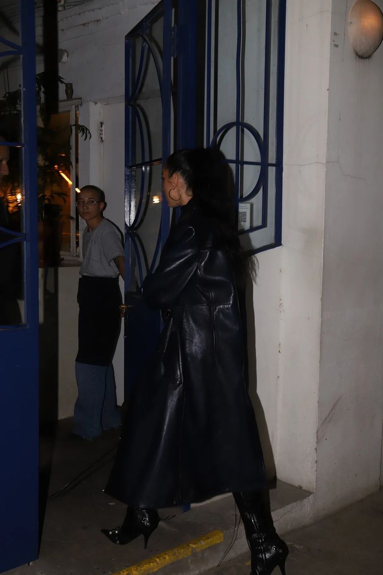 Con un tapado negro, botas a juego y debajo un vestido con medias, la artista llegó al restaurante después de brindar su show