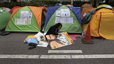 americateve | Un manifestante prodemocracia realiza un dibujo en una zona ocupada fuera de la sede del gobierno, en el distrito Admiralty de Hong Kong, el 13 de noviembre de 2014. (Foto AP/Vincent Yu)