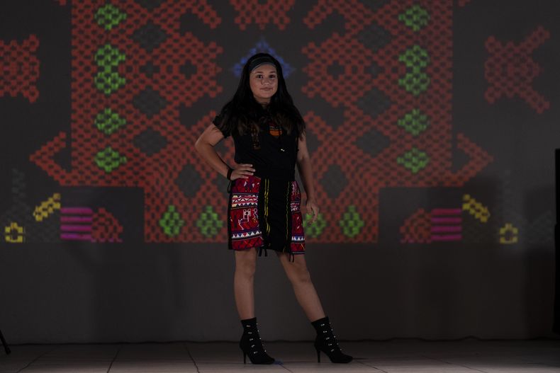 Una modelo luce prendas durante un desfile de modas con textiles guatemaltecos, el viernes 12 de mayo de 2023, en Brownsville, Texas. Elena de León, una diseñadora nacida en Guatemala, combinó técnicas indígenas de tejido, diseño moderno de ropa y colorida historia de su país natal en esa exhibición, la cual ofreció una muestra no sólo de su visión artística, sino un trabajo de madres guatemaltecas, incluidas algunas que viven en Estados Unidos y otras que se quedaron en su país para apoyar a sus familias. (AP Foto/Julio Cortez)