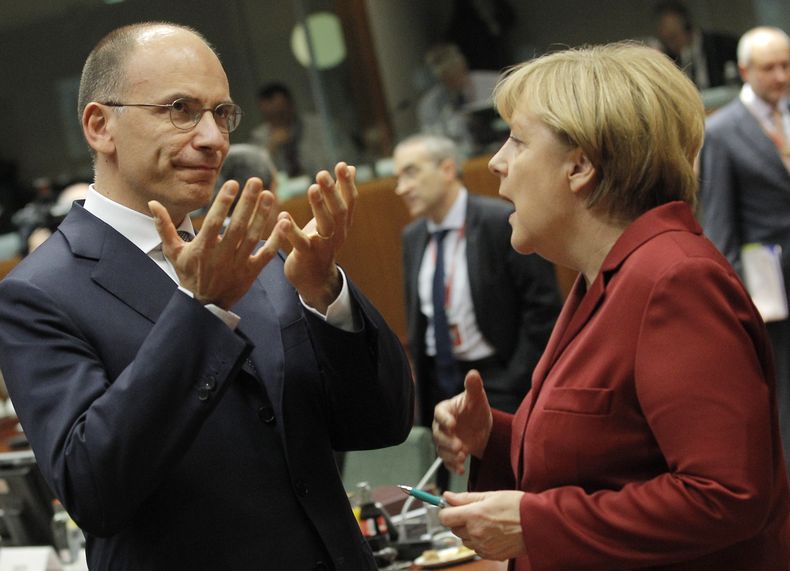 El primer ministro italiano Enrico Letta habla con la canciller alemana Angela Merkel durante una mesa redonda en la cumbre de la UE en Bruselas el jueves, 24 de octubre del 2013.  (Foto AP/Yves Logghe)