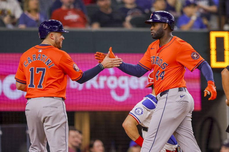 Víctor Caratini (17) de los Astros de Houston y su compañero de equipo Yordan Álvarez (44) celebran después de que Álvarez conectó un jonrón de dos carreras durante la segunda entrada del juego de béisbol contra los Rangers de Texas, el lunes 8 de abril de 2024, en Arlington, Texas. (AP Foto/Gareth Patterson)