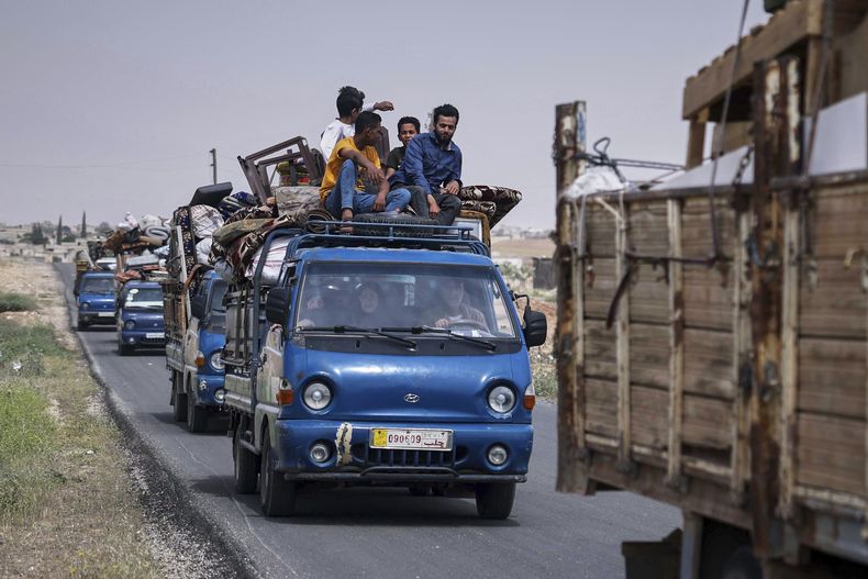 Camionetas con alrededor de 60 familias desplazadas a bordo llegan a Kafr Sijna, al sur Idlib, Siria, el domingo 18 de mayo de 2025. (AP Foto/Ghaith Alsayed)