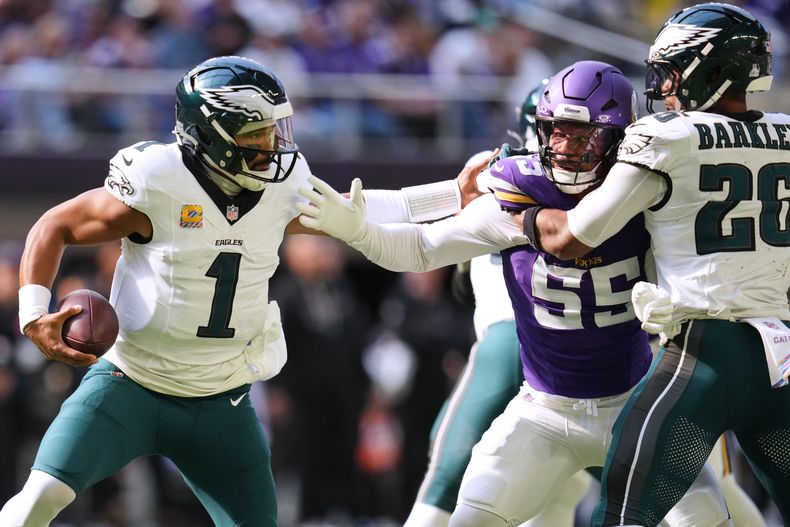 El quarterback de los Eagles de Filadelfia Jalen Hurts intenta evitar una tackleada del linebacker de los Vikings de Minnesota Eric Wilson en el encuentro del domingo 19 de octubre del 2025. (AP Foto/Abbie Parr)