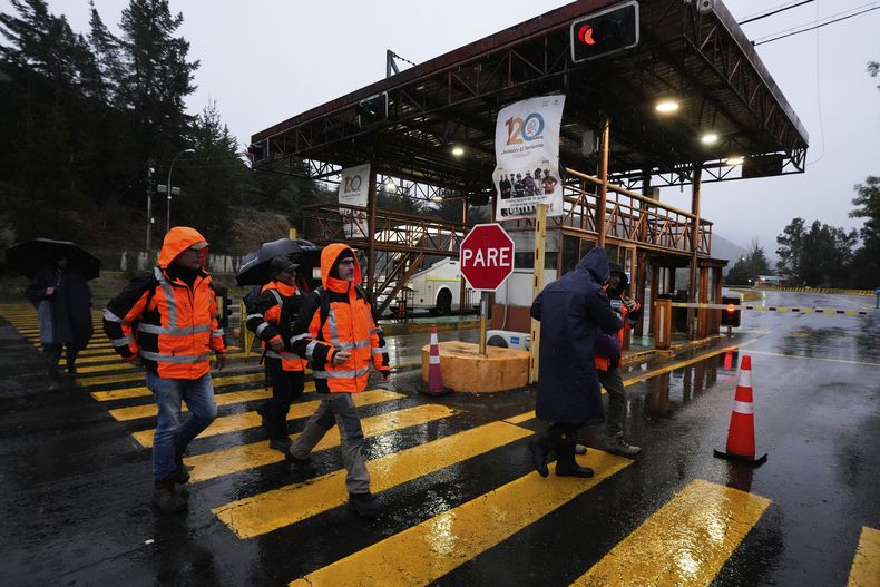 Trabajadores caminan a la entrada de la mina de cobre El Teniente, operada por Codelco en Chile, donde un derrumbe mató a un trabajador y atrapó a otros cinco bajo tierra, lo que provocó la suspensión de las operaciones en Rancagua, Chile, el viernes 1 de agosto de 2025. (Foto AP/Esteban Félix)