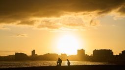 Dos hombres pescan en el Malecón al amanecer durante un apagón en La Habana, Cuba, el domingo 22 de marzo de 2026. (Foto AP/Ramon Espinosa)