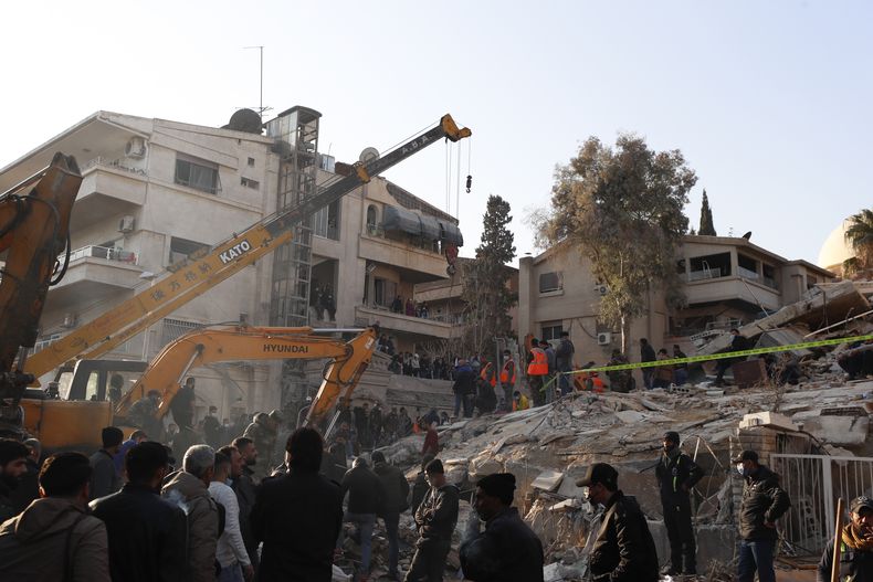 Personal del servicio de emergencias realiza tareas en un edificio impactado por un ataque aéreo israelí en Damasco, Siria, el sábado 20 de enero de 2024. (AP Foto/Omar Sanadiki)