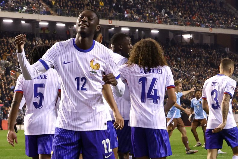 El francés Randal Kolo Muani, a la izquierda, celebra después de anotar el segundo gol de su equipo durante el partido de fútbol del grupo A2 de la Liga de Naciones de la UEFA entre Bélgica y Francia en el estadio Rey Balduino en Bruselas, Bélgica, el lunes 14 de octubre de 2024. (AP Foto/Geert Vanden Wijngaert)