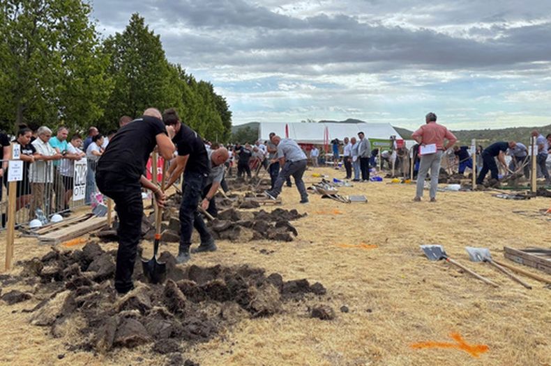 En la imagen, proporcionada por Lili Szandelszky, varios cavadores de tumbas compiten en un concurso destinado a sacudirse los tabúes relacionados con la muerte, en el cementerio público de Nyergesújfalu, Hungría, el sábado 5 de septiembre de 2026. (Lili Szandelszky vía AP)