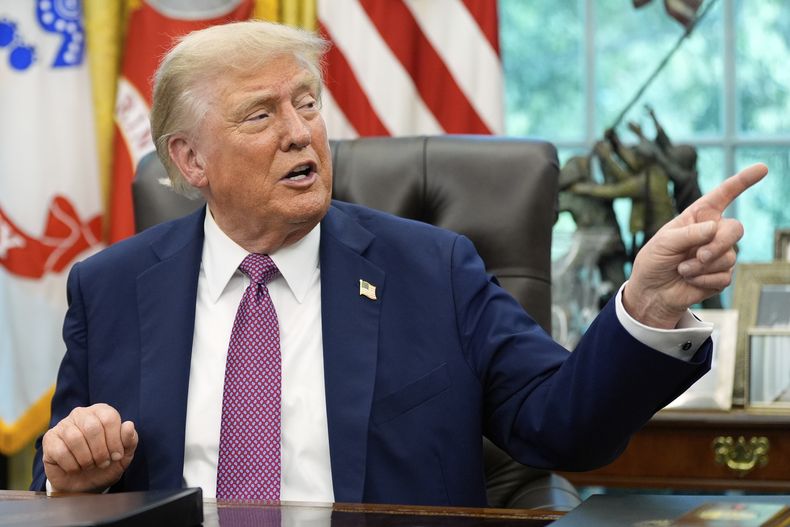 El presidente Donald Trump señala un cartel del G20 de Miami 2026 mientras habla en el Despacho Oval de la Casa Blanca, el viernes 5 de septiembre de 2025, en Washington. (AP Photo/Alex Brandon)