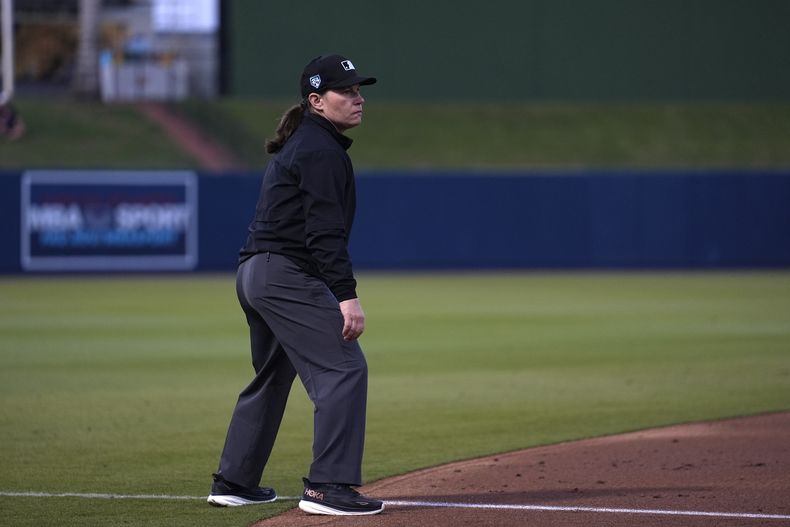 La umpire Jen Pawol toma su posición en la tercera base durante el juego de béisbol de entrenamiento de primavera entre los Nacionales de Washington y los Astros de Houston el sábado 24 de febrero de 2024, en West Palm Beach, Florida. Pawol dio un gran paso para romper la barrera de género para los árbitros de las Grandes Ligas cuando se convirtió en la primera mujer en 17 años en trabajar en un juego de entrenamiento de primavera de las Grandes Ligas el sábado por la noche. (AP Foto/Jeff Roberson)