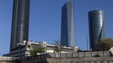 americateve | Un hombre mira sobre a valla que resguarda edificios de oficinas en el distrito financiero de madrid, Espa&ntilde;a el viernes 11 de abril de 2014. La oficina de estad&iacute;sticas espa&ntilde;ola inform&oacute; que el riesgo de deflaci&oacute;n se ha re