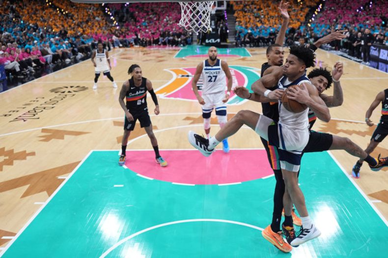 Terrence Shannon Jr. (1), al frente, de los Timberwolves de Minnesota, controla el balón mientras Dylan Harper (2), al medio, y Victor Wembanyama (1), atrás, defienden durante la segunda mitad del primer juego de la serie de segunda ronda de playoffs del baloncesto de la NBA, el lunes 4 de mayo de 2026, en San Antonio. (AP Foto/Eric Gay)