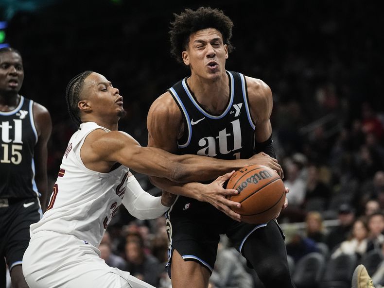 Jalen Johnson (1), de los Hawks de Atlanta, es defendido por Isaac Okoro (35), de los Cavaliers de Cleveland, mientras intenta alzarse para encestar durante la primera mitad del juego de baloncesto de la NBA el miércoles 6 de marzo de 2024, en Atlanta. (AP Foto/John Bazemore)