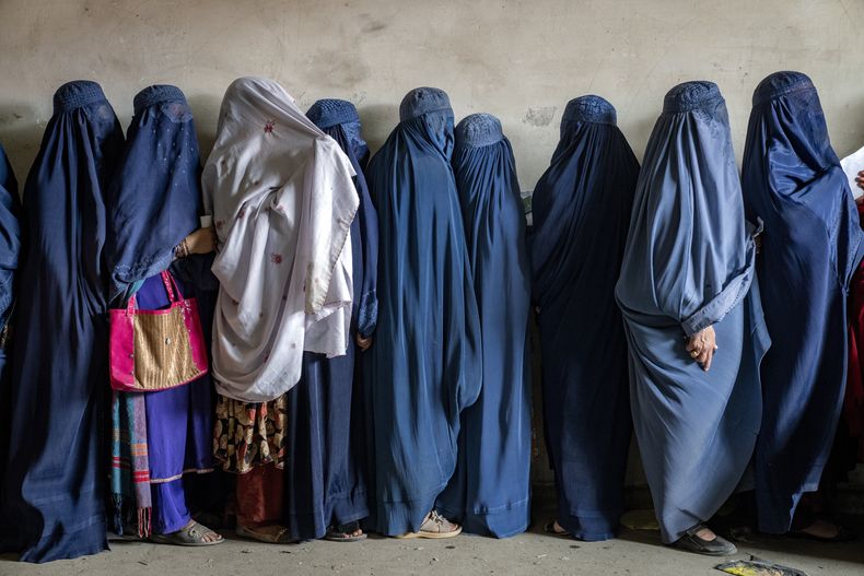 Mujeres afganas esperan recibir raciones de alimentos distribuidas por un grupo de ayuda humanitaria, en Kabul, Afganistán, el martes 23 de mayo de 2023. (Foto AP/Ebrahim Noroozi, Archivo)