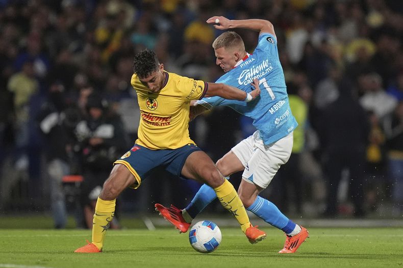 Sebastián Cáceres (izquierda) del América y Mateusz Bogusz de Cruz Azul pugnan por el balón en los cuartos de final de la Copa de Campeones de la CONCACAf, el martes 8 de abril de 2025. (AP Foto/Eduardo Verdugo)