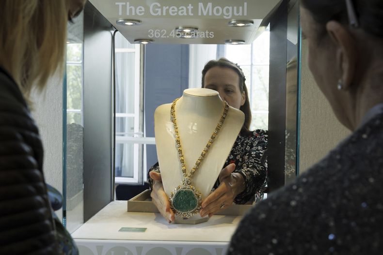 Una empleada de Christies exhibe el collar de diamantes y esmeraldas Great Mogul creador por Harry Winston, con un precio estimado entre 450.000 y 640.000 francos suizos, en una vitrina, durante la vista previa de El mundo de Heidi Horten, la colección de 700 joyas de la difunta multimillonaria austriaca Heidi Horten, en la casa de subastas Christies en Ginebra, Suiza, el lunes 8 de mayo de 2023. (Salvatore Di Nolfi/Keystone vía AP)
