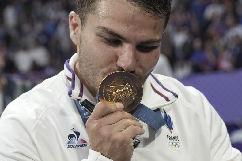 El francés Antoine Dupont besa su medalla de oro luego que Francia venció a Fiyi en la final del rugby sevens de los Juegos Olímpicos de París, el sábado 27 de julio de 2024, en Saint-Denis, Francia. (AP Foto/Tsvangirayi Mukwazhi)