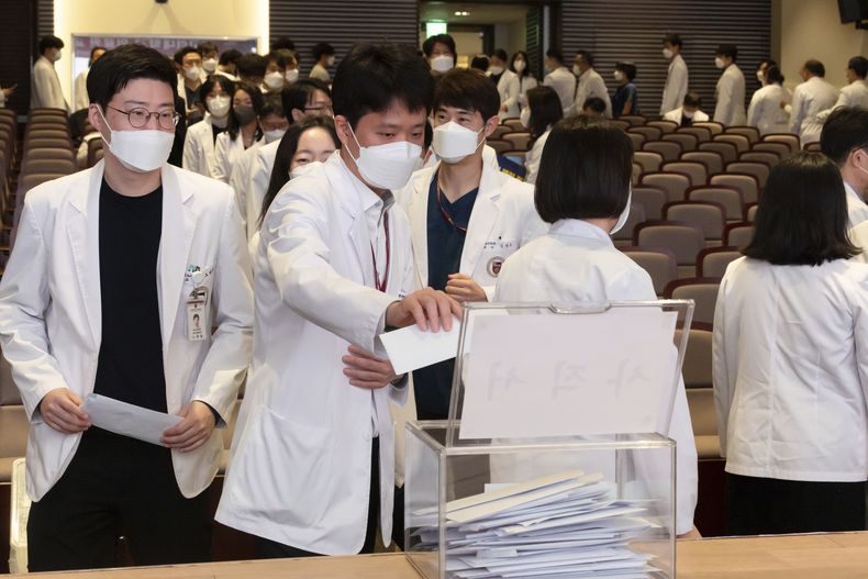 Profesores de medicina hacen fila para presentar sus renuncias durante una reunión en la Universidad de Corea en Seúl, Corea del Sur, el lunes 25 de marzo de 2024. Médicos veteranos de grandes hospitales surcoreanos empezaron a renunciar en masa el lunes en apoyo de los médicos en prácticas y residentes, que llevan cinco semanas en huelga por un plan del gobierno para aumentar de forma drástica las plazas en facultades de medicina. (Yoon Dong-jin/Yonhap via AP)