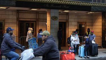 Miembros de la familia Goya esperan ser trasladados, con sus pertenencias, frente al Hotel Roosevelt de Nueva York, el martes 25 de febrero de 2025. (AP foto/Seth Wenig)
