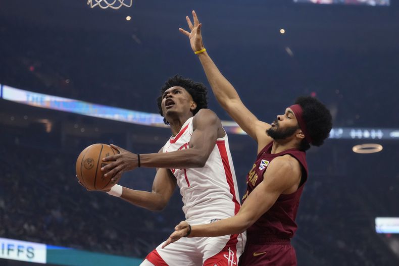 El alero de los Rockets de Houston, Amen Thompson (1), se dirige a la canasta defendida por el pívot de los Cavaliers de Cleveland, Jarrett Allen, a la derecha, en la primera mitad de un partido de baloncesto de la NBA, el sábado 25 de enero de 2025, en Cleveland. (AP Foto/Sue Ogrocki)