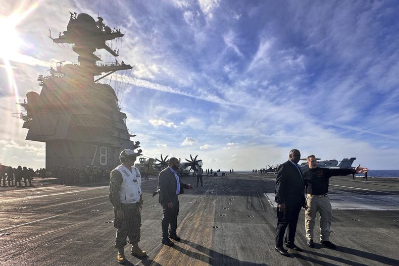 El secretario de Defensa de EEUU, Lloyd Austin, segundo de la derecha, habla con el oficial al mando del USS Gerald R. Ford, capitán Rick Burgess, a la derecha, durante una visita al portaaviones el miércoles 20 de diciembre de 2023. (AP Foto/Tara Copp)