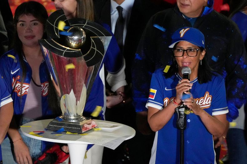 La presidenta interina de Venezuela, Delcy Rodríguez, a la derecha, a un costado del trofeo del Clásico Mundial de Béisbol un día después de que el equipo de Venezuela derrotó en la final a Estados Unidos, el miércoles 18 de marzo de 2026, en el Palacio Presidencial de Miraflores, en Caracas. (AP Foto/Ariana Cubillos)