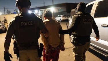 Agentes de un equipo de Investigaciones de Seguridad Nacional llevan a un sospechoso de registrarse de forma ilegal para votar durante una operación federal en Commerce, California, el lunes 19 de octubre de 2026. (AP Foto/Jae C. Hong)