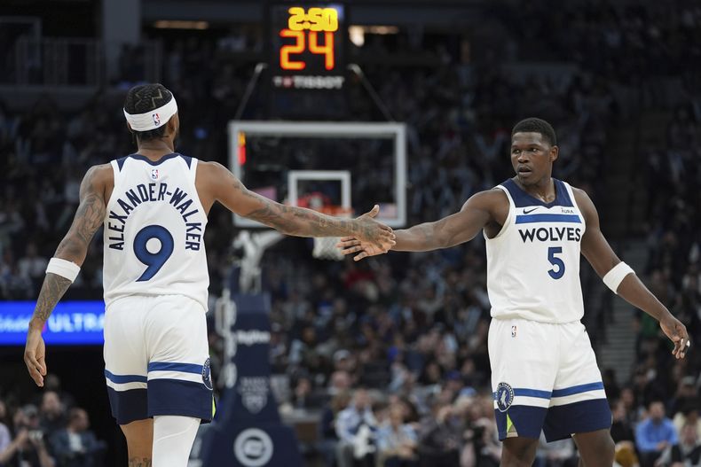 Los armadores de los Timberwolves de Minnestoa Nickeil Alexander-Walker (9) y Anthony Edwards (5) se saludan durante la segunda mitad del juego de baloncesto de la NBA, ante los Pistons de Detroit, el miércoles 27 de marzo de 2024, en Mineápolis. (AP Foto/Abbie Parr)
