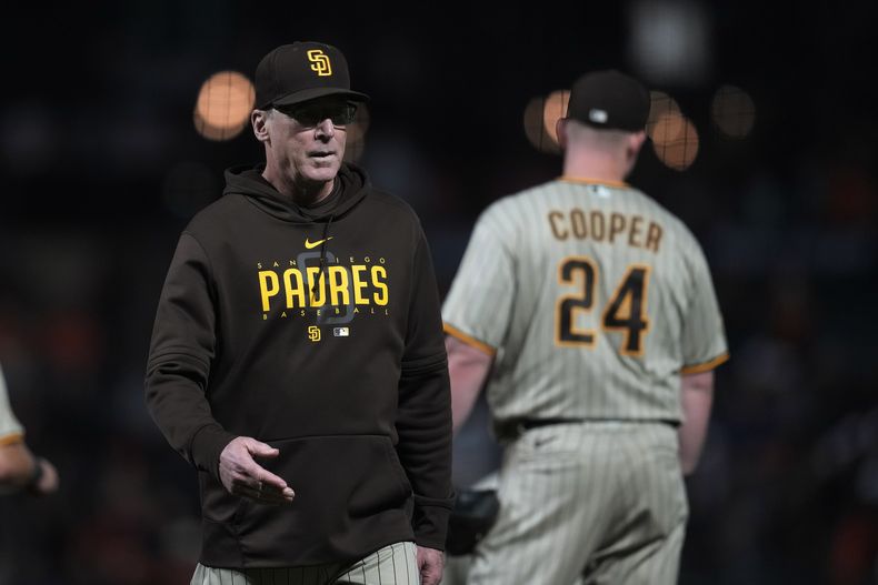 Bob Melvin (izquierda) mánager de los Padres de San Diego, camina hacia el banquillo luego de realizar un cambio de lanzadores en la novena entrada del juego de beisbol ante los Gigantes de San Francisco, en San Francisco, el martes 26 de septiembre de 2023. (AP Foto/Jeff Chiu)
