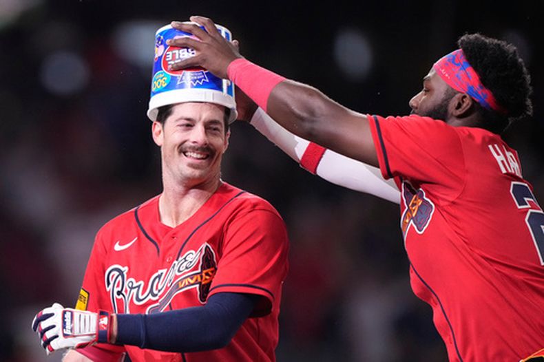 Mike Yastrzemski (izquierda), de los Bravos de Atlanta, festeja en la décima entrada del juego ante los Medias Rojas de Boston, el viernes 15 de mayo de 2026 (AP Foto/Brynn Anderson)