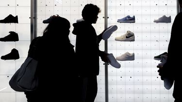 ARCHIVO - Algunas personas adquieren zapatos deportivos en una tienda Nike el 25 de noviembre de 2022, en Nueva York. (AP Foto/Julia Nikhinson, archivo)