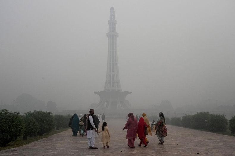 Familias llegan al monumento de Pakistán el viernes 8 de noviembre de 2024 en medio de altos niveles de contaminación, en Lahore, Pakistán. (AP Foto/K.M. Chaudary)