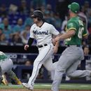 Nick Fortes (centro) de los Marlins de Miami anota una carrera ante los Atléticos de Oakland, el domingo 4 de junio de 2023, en Miami. (AP Foto/Wilfredo Lee)