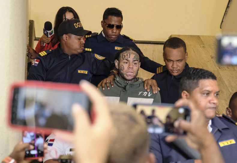 ARCHIVO - El rapero Daniel Hernández, conocido como Tekashi 6ix9ine, es escoltado por la policía al llegar a una audiencia judicial en el Palacio de Justicia, en Santo Domingo, República Dominicana, el 25 de enero de 2024. (Foto AP/Ricardo Hernandez, archivo)