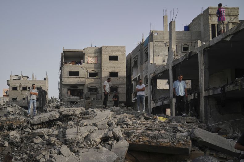 Personas inspeccionan los escombros de la casa de la familia Al-Aimawi, la cual fue destruida por bombardeos de Israel en Al-Zawaideh, Franja de Gaza, el martes 1 de julio de 2025. (AP Foto/Abdel Kareem Hana)