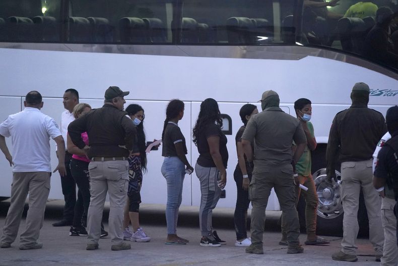 ARCHIVO - Varios migrantes hacen fila para abordar un bus después de ser deportados de Estados Unidos, de regreso a Matamoros, México, el 11 de mayo de 2023. (AP Foto/Fernando Llano, Archivo)