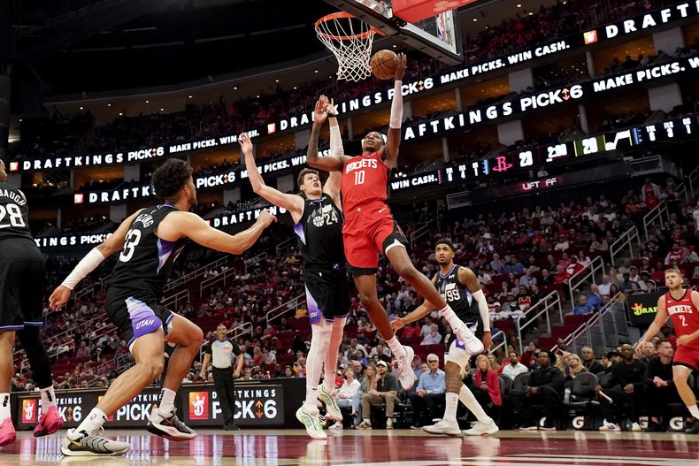 Jabari Smith Jr. (10), de los Rockets de Houston, ataca la canasta mientras Walker Kessler (24), del Jazz de Utah, defiende durante la primera mitad del juego de baloncesto de la NBA, el miércoles 2 de abril de 2025, en Houston. (AP Foto/Eric Christian Smith)