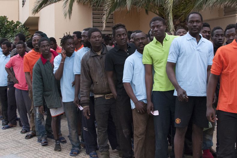 Migrantes sub-saharianos se forman junto a una estaci&oacute;n de polic&iacute;a despu&eacute;s de saltar la cerca que separa Marruecos del enclave espa&ntilde;ol de Melilla, el lunes 17 de febrero de 2014. (Foto AP/ Jes&uacute;s Blasco de Avellaneda)