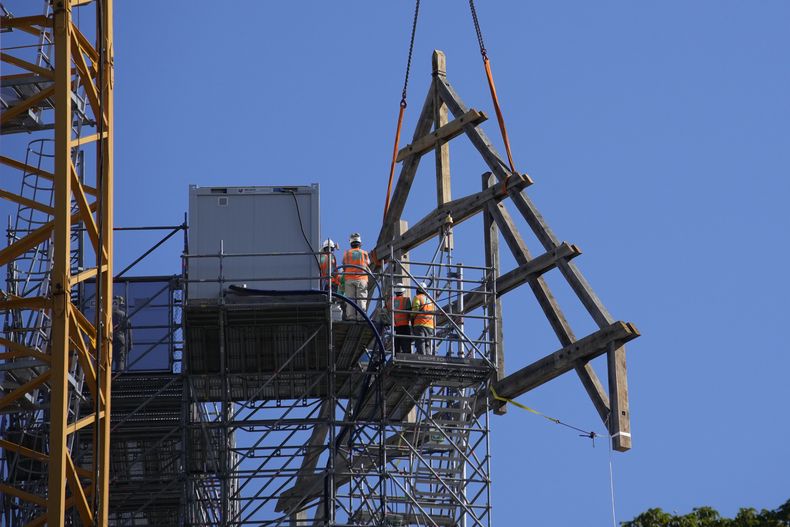 Trabajadores junto a un enorme marco de roble en la catedral de Notre Dame de París, el martes 11 de julio de 2023 en París. Los paneles se volverán a montar en la parte superior de Notre Dame para reemplazar el techo que las llamas convirtieron en cenizas en 2019. (Foto AP/Christophe Ena)