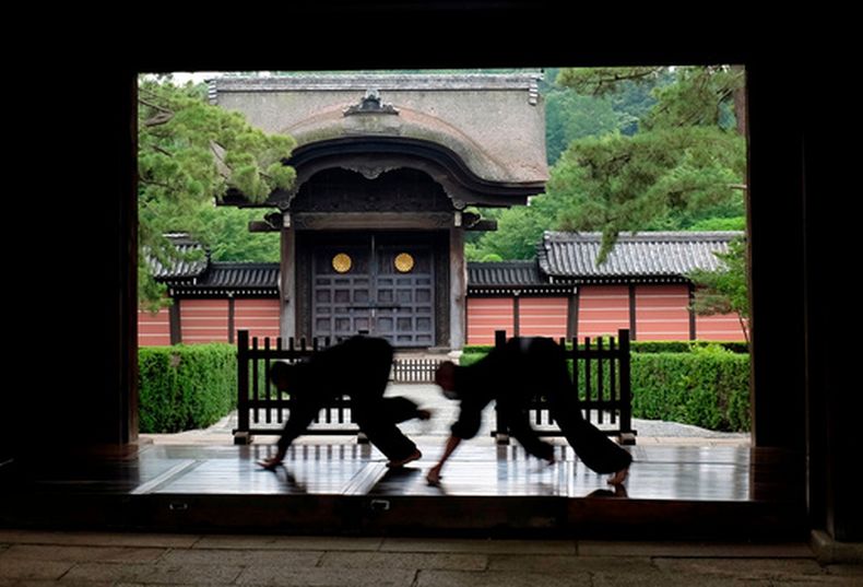 ARCHIVO - Monjes pulen el pasillo de madera que conecta los edificios del templo Soji-ji en Yokohama, Japón, el 5 de julio de 2016. (AP Foto/Kiichiro Sato/Archivo)
