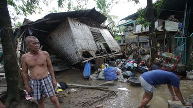 americateve | Vecinos frente a sus viviendas da&ntilde;adas horas despu&eacute;s que el tif&oacute;n Nari golpe&oacute; el poblado de San Miguel, en la provincia de Bulacan, en el norte de Filipinas, el domingo 13 de octubre de 2013. (Foto AP/Aaron Favila)